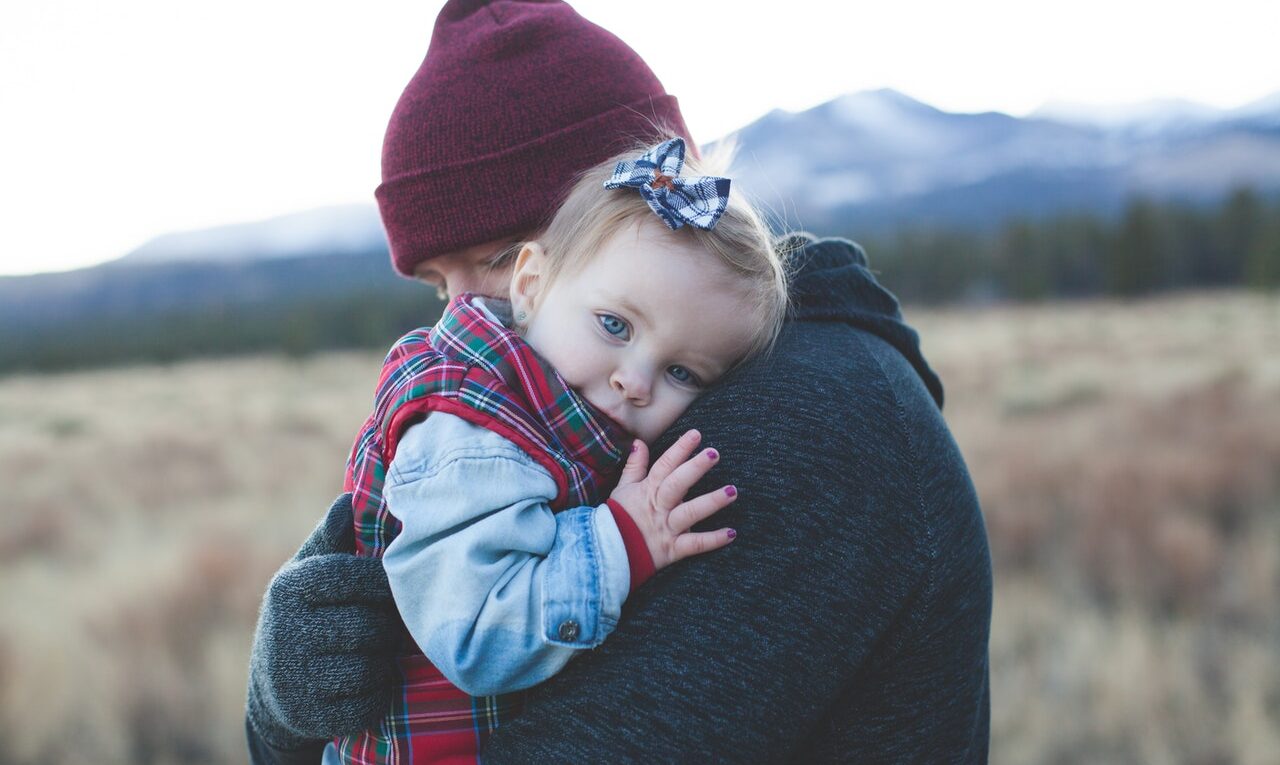 Mężczyzna przytula swoje dziecko po ukąszeniu kleszcza